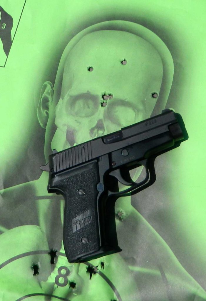 SIG Sauer P228 pistol on green skeleton target