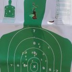 Green silhouette target peppered by a shotgun