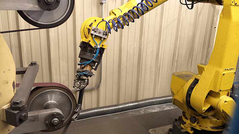 Robotic arm precision grinding a gun barrel
