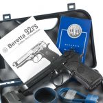 Instruction manual, gun lock, and spare magazine with theBeretta M9.