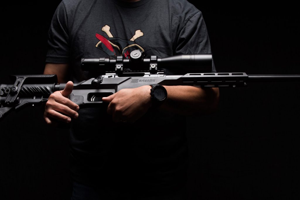 Man holding a Savage Model 10 BA Stealth rifle for Anti-Discrimination laws