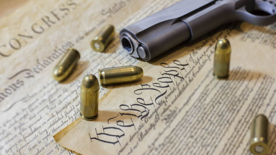 Constitution with bullets and a handgun