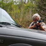 Bob Campbell shooting a rifle over the hood of a pickup truck