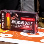 A box of American Eagle Syntech ammunition atop a paper bulls eye target