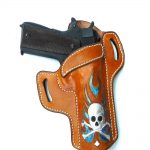 1911 pistol in a brown leather holster with a skull painted on it