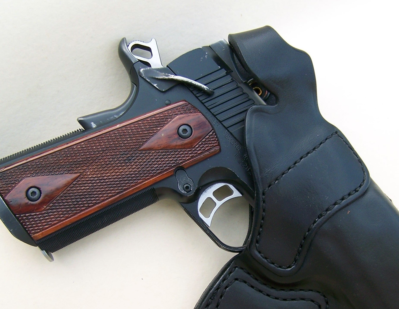 1911 pistol cocked and locked in a black leather holster