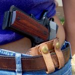 Woman carrying a 1911 pistol with the hammer down