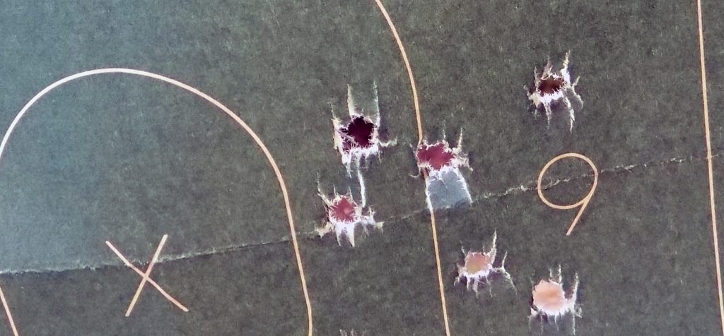 paper target with four bullet holes