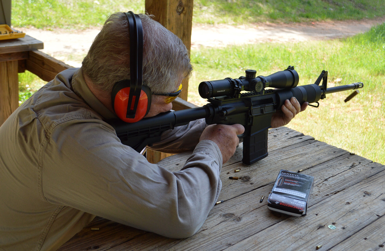 Bob Campbell firing a scoped AR-15 from a benchrest position for rifle marksmanship