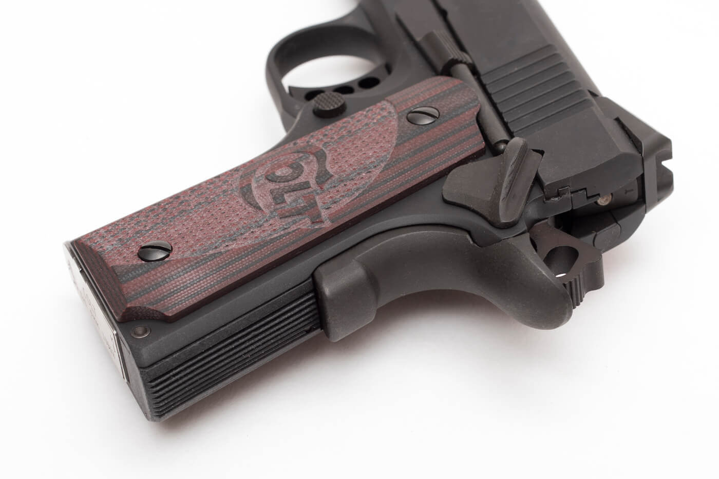 Grip serrations and beavertail safety of a Colt 1911 pistol.