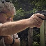 Bob Campbell shooting a pistol one handed