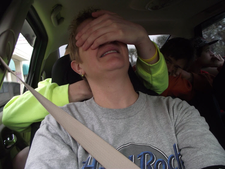 Man being attacked from the backseat of the car