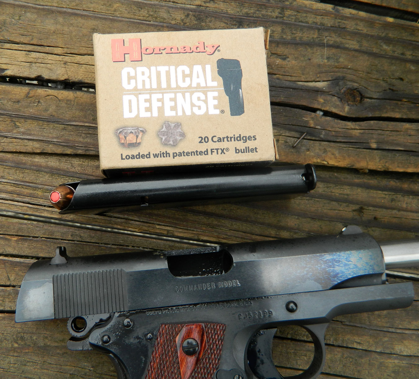 Colt 1911 with slide locked back and a box of Hornady Critical Defense ammunition