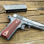 Blued steel 1911 handgun with wood grips