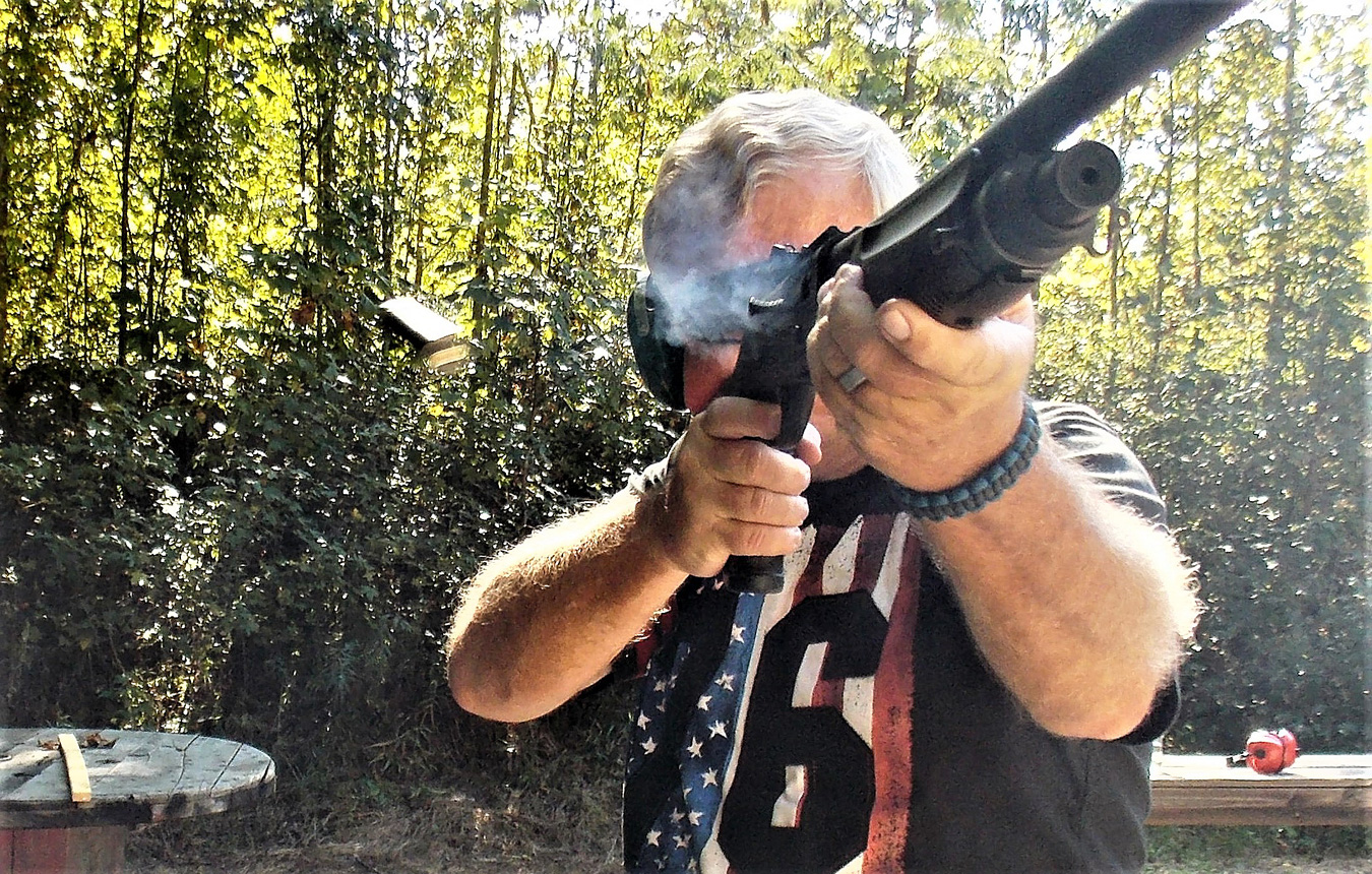 Bob Campbell shooting a shotgun as a shell is being ejected