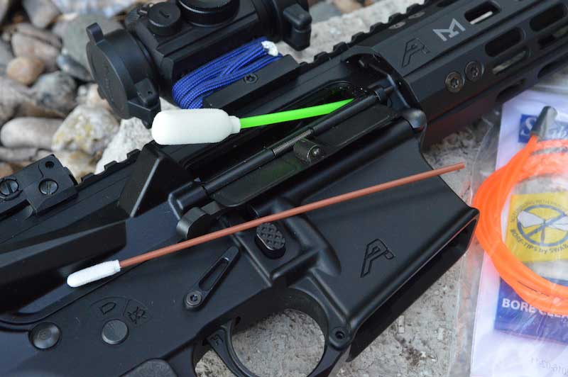 Swab-its bore cleaner being inserted into the bore of an AR-15 rifle