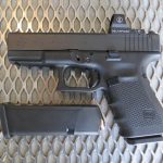 Glock G19 MOS pistol left side with spare magazine