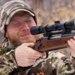 Man flinching while shooting a rifle