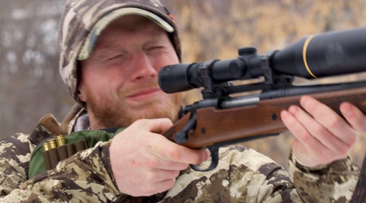 Man flinching while shooting a rifle