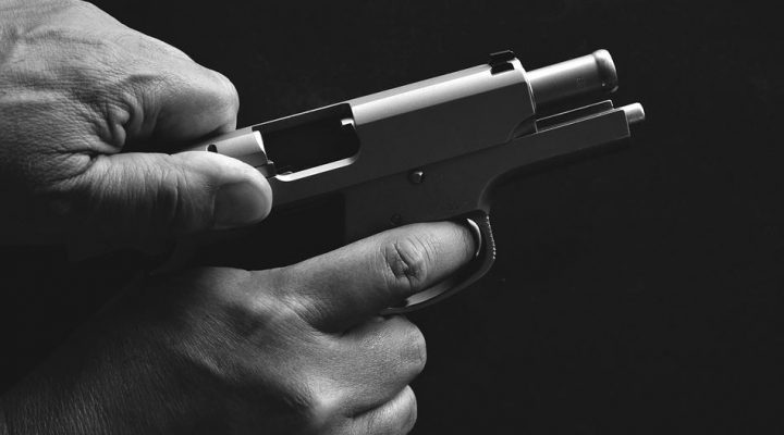 Handgun slide being racked to load a cartridge into the chamber