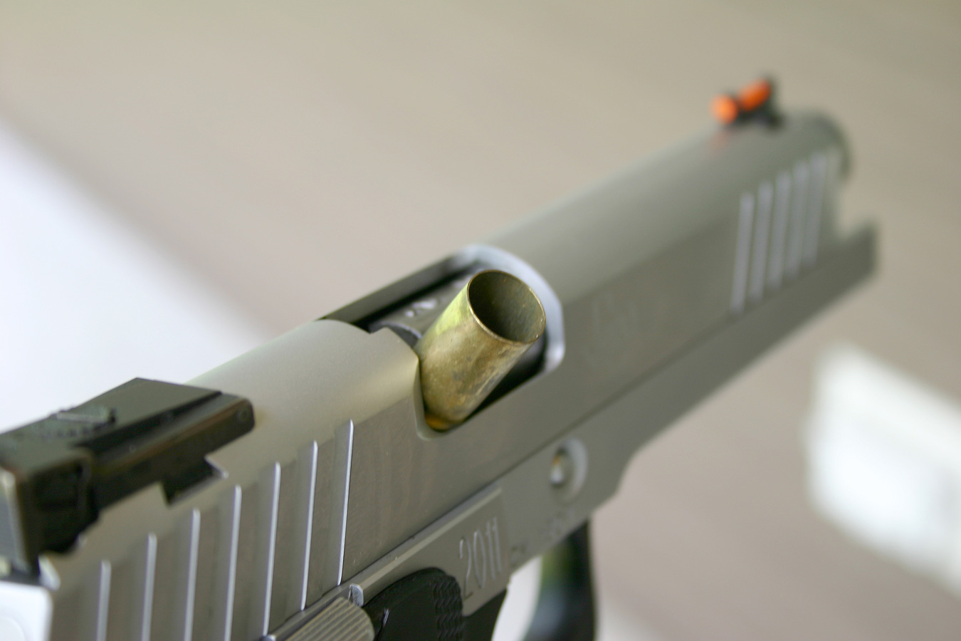 Semi automatic pistol with a cartridge case stovepiped in the ejection port for Jams and Malfunctions