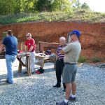 Men standing around on a shooting range discussing tactics