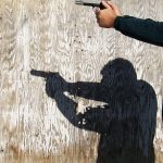 Shadow of a man holding a pistol