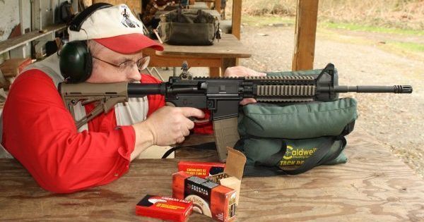 Dave Workman shooting an AR-15 from a benchrest at a talk about Universal Background Checks