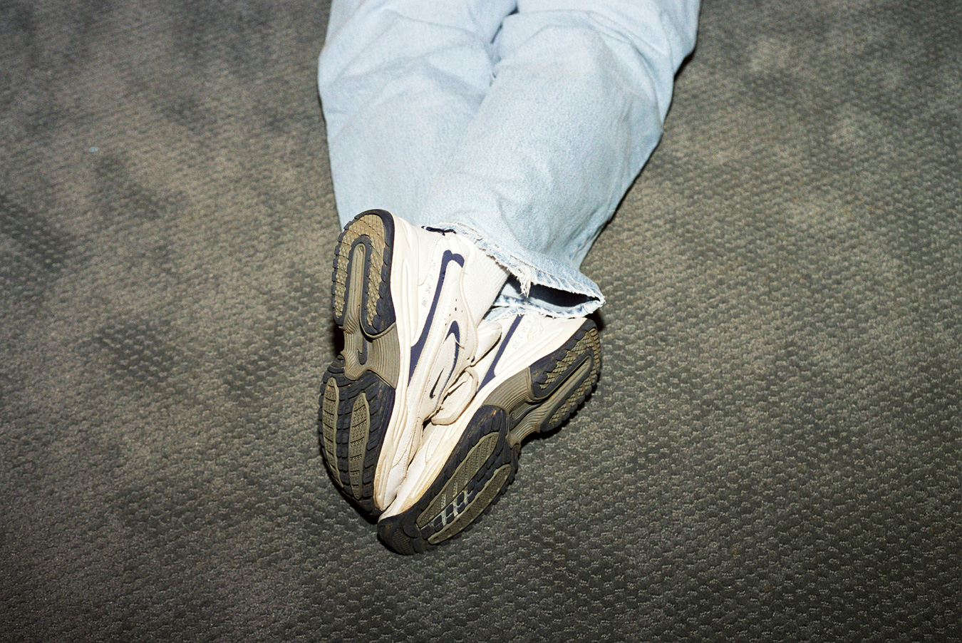 man's feet crossed while laying face down
