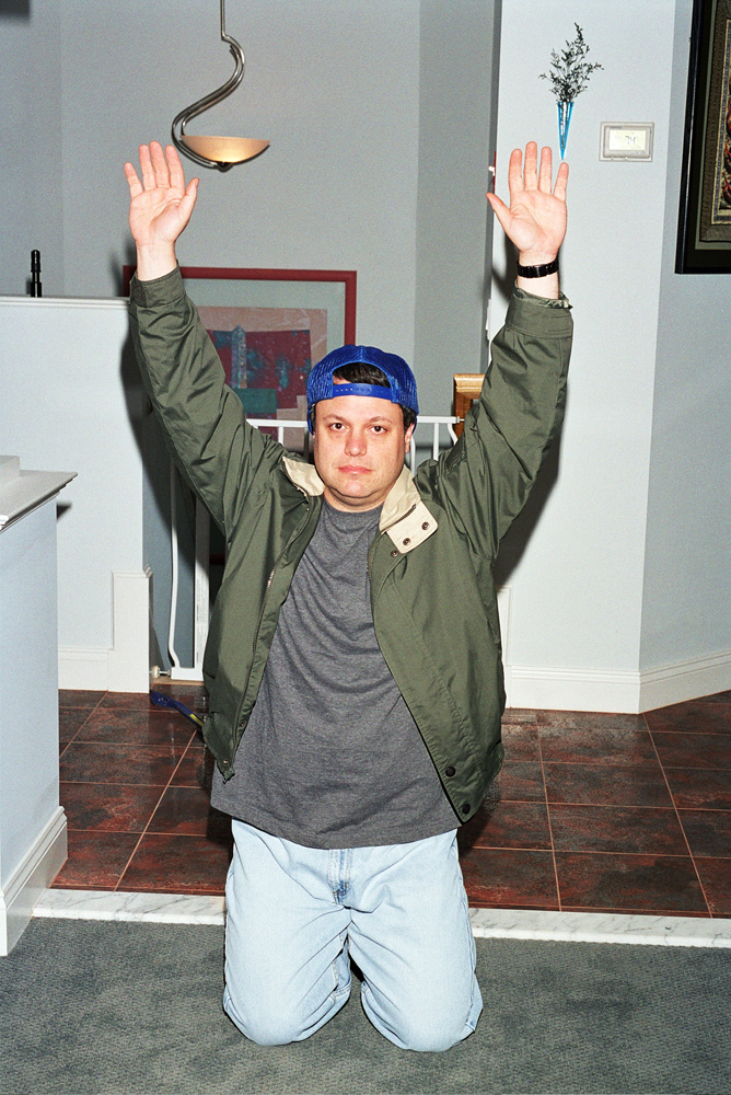 Man on his knees with his hands over his head