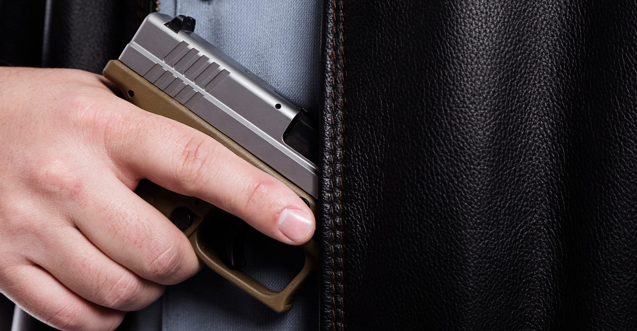 Armed good guy removing gun from under his jacket