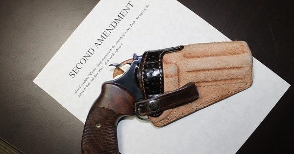 Revolver in leather holster on a copy of the Second Amendment for Gun Laws