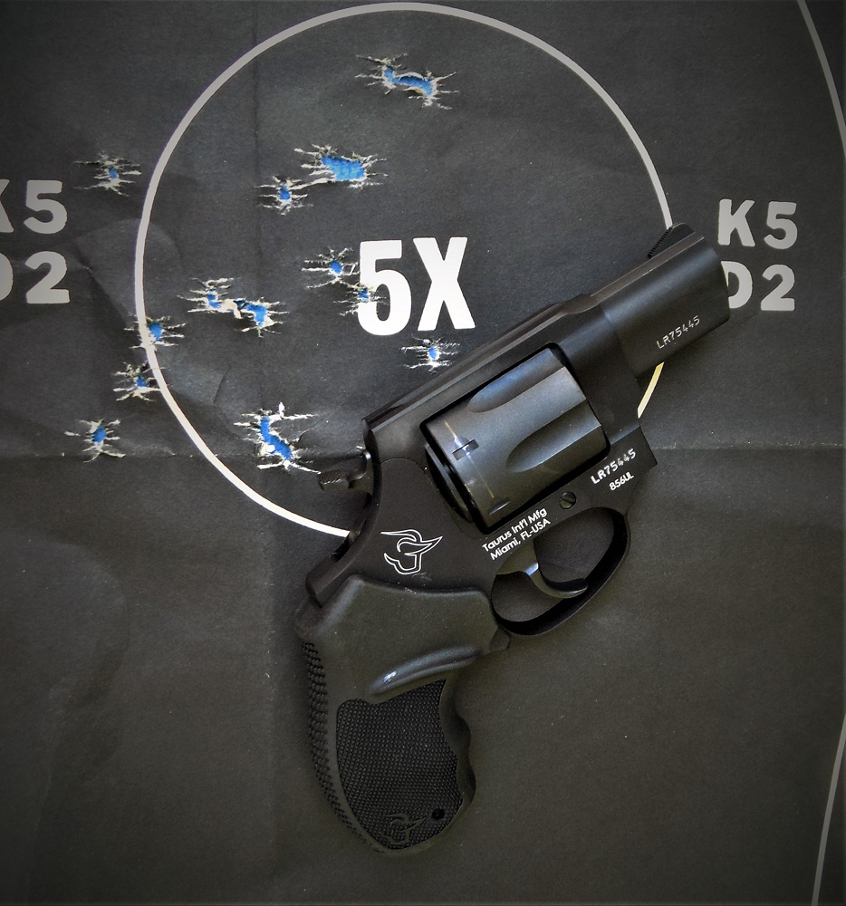 Revolver with several bullet holes in the five ring of the target showing good training