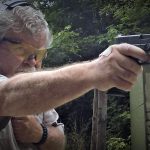 Bob Campbell shooting a pistol one-handed