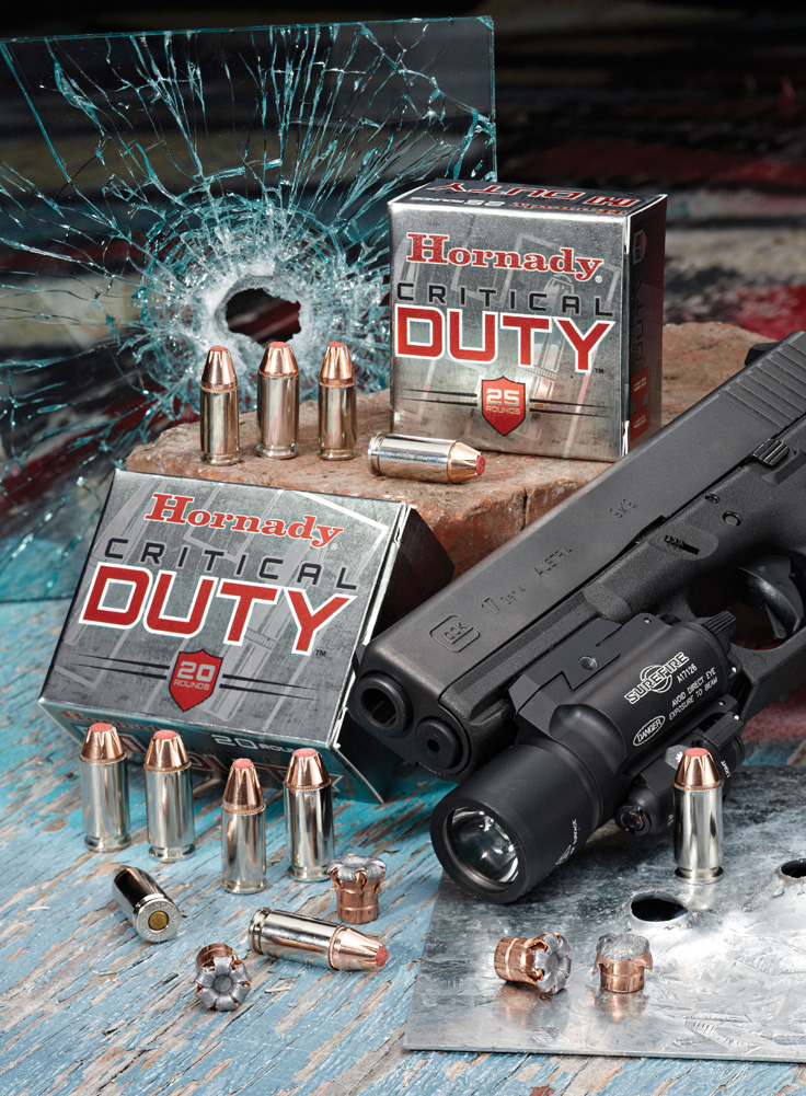 Hornady Critical Defense ammunition box in front of a windshield with a bullet hole