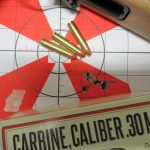 red and white target with .30 caliber bullet and a 5-shot group