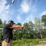 Shooting a 9mm pistol with four cartridge cases in the air