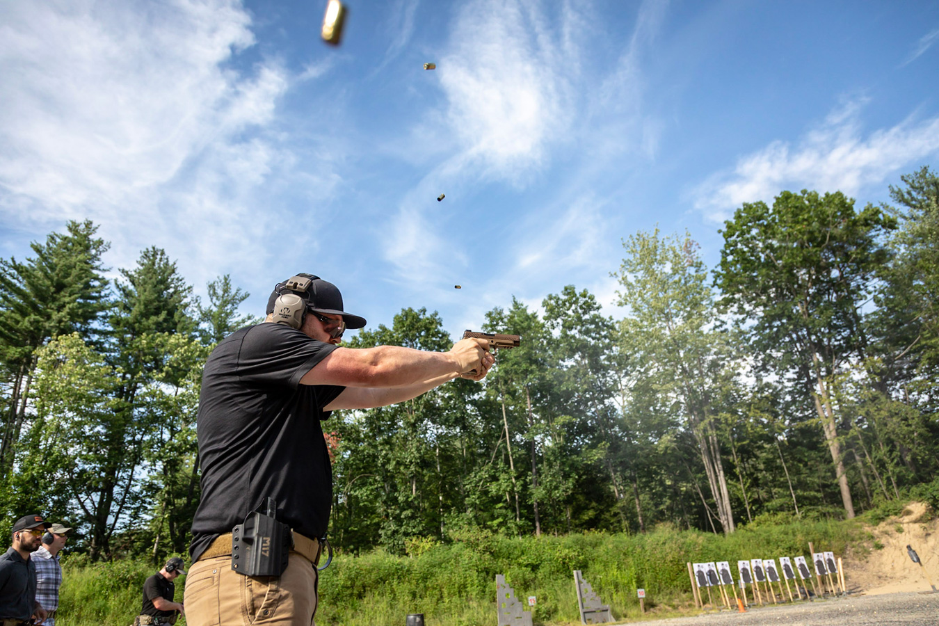 Shooting a 9mm pistol with four cartridge cases in the air