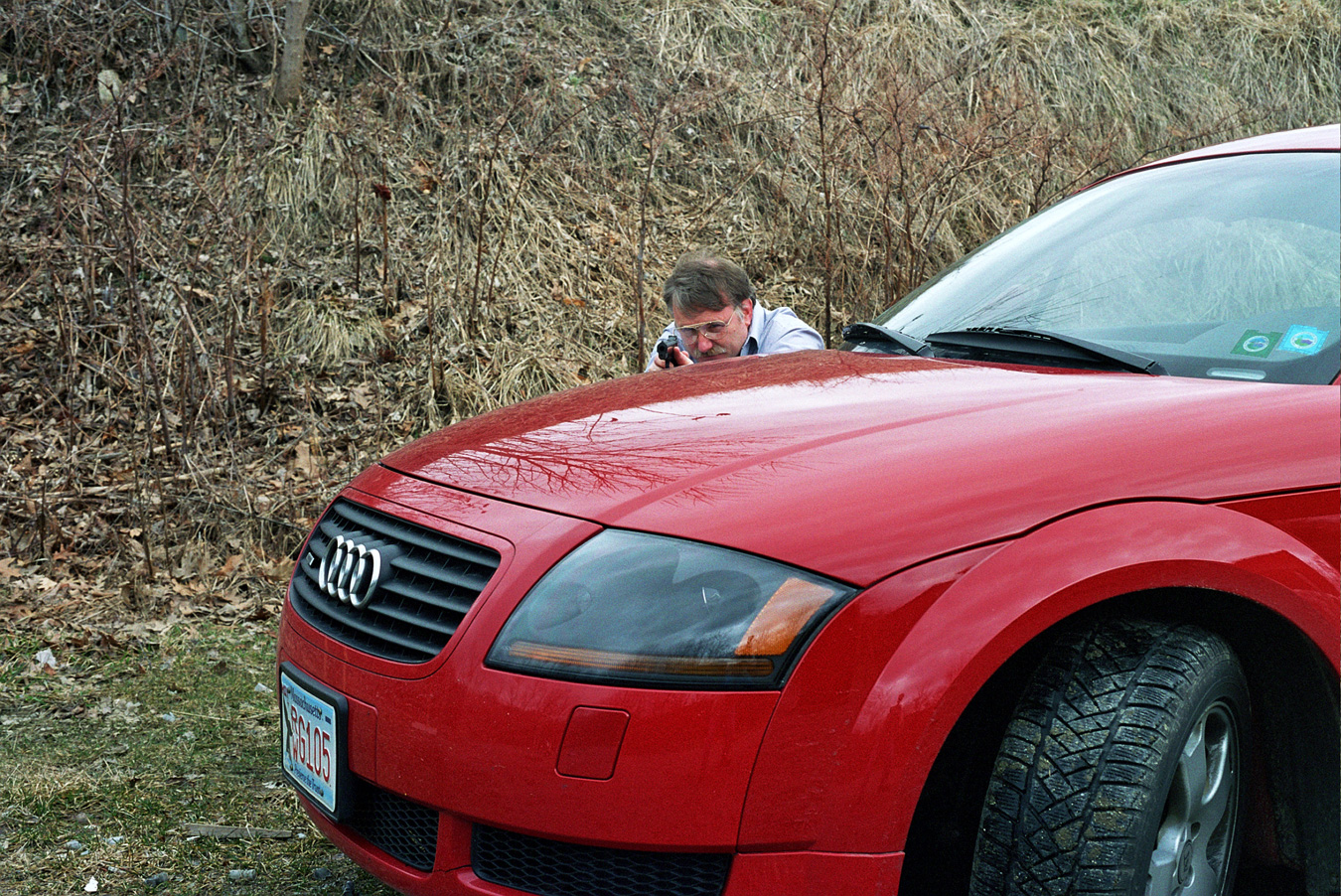Shooting a pistol while using the front end of a car for cover
