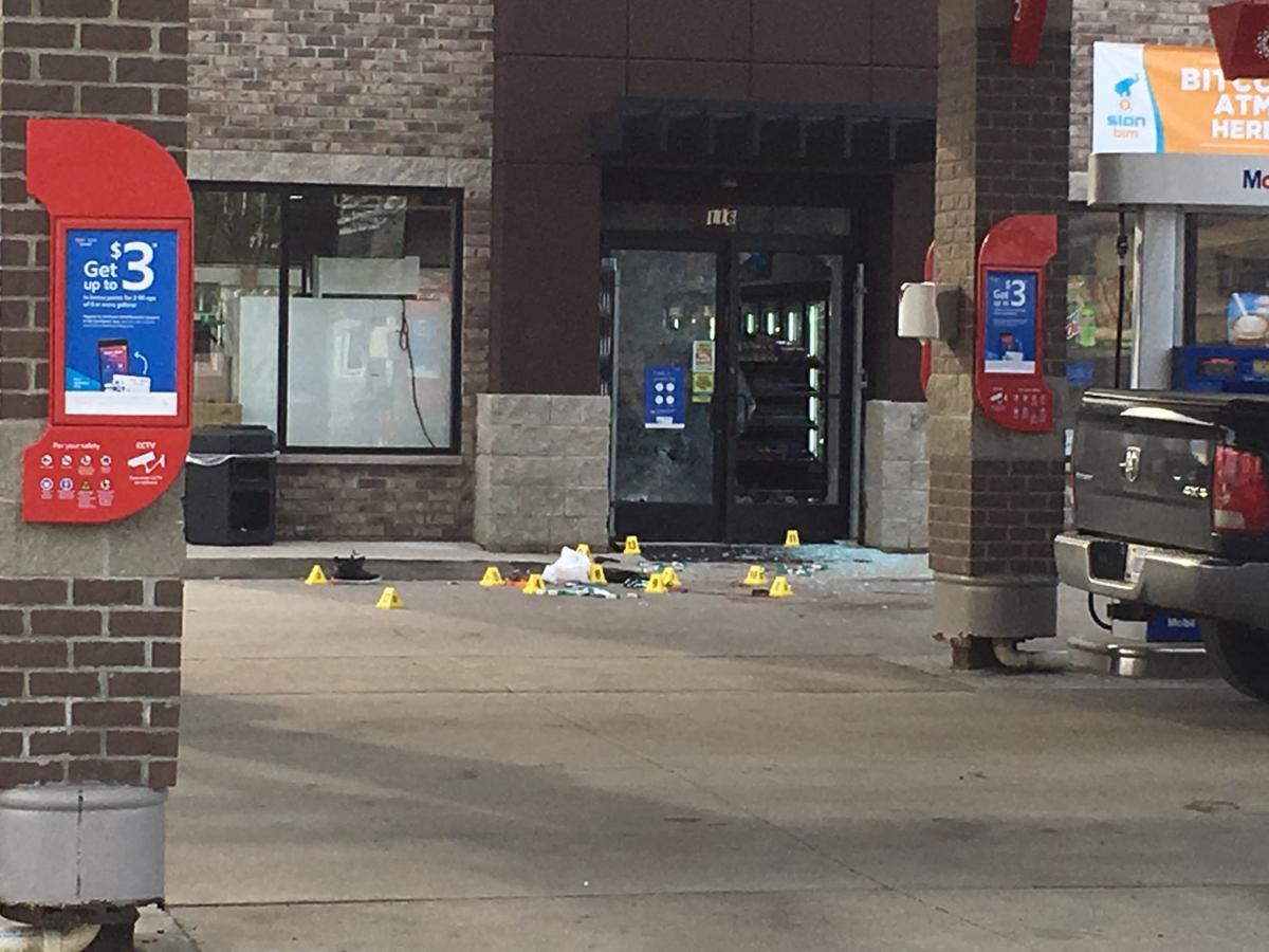 Broken glass and evidence markers at a gas station