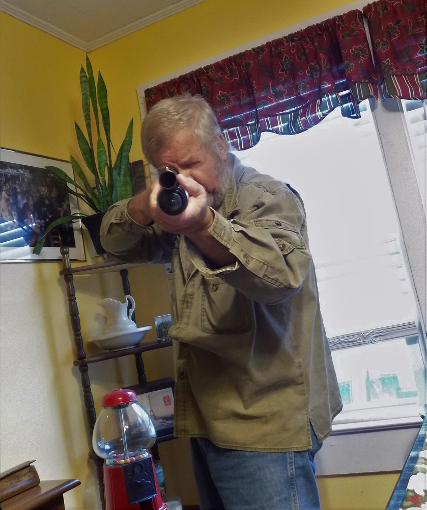 Bob Campbell in a defensive position aiming a shotgun