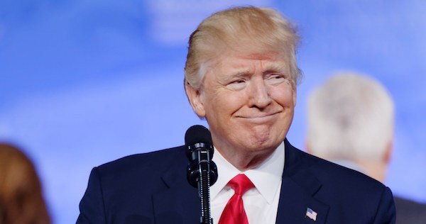 President Trump smiling while speaking at the podium
