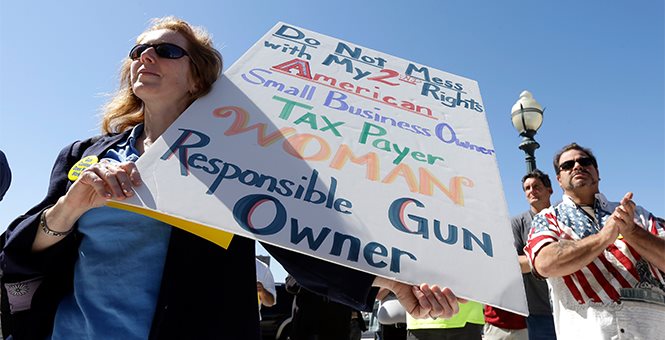 Armed Good Guys holding a sign protesting gun control