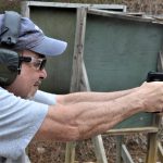Man wearing hearing protection shooting the Taurus TX22 pistol