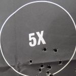 Silhouette target with multiple bullets holes in the 5 ring