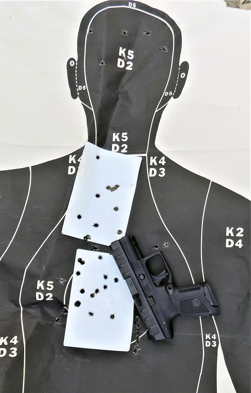 pistol atop a silhouette target with bullet holes