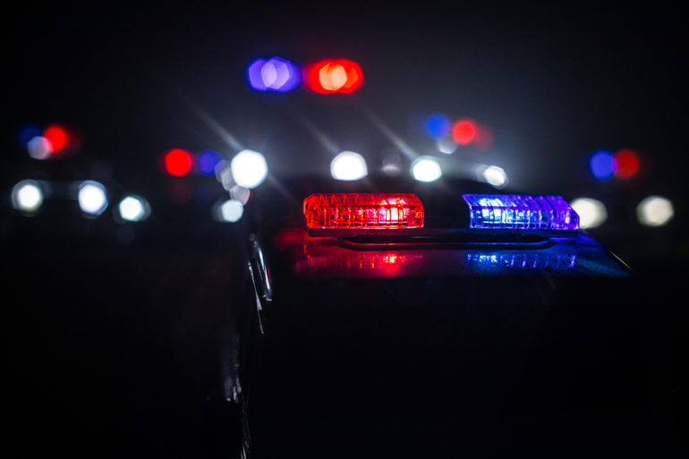 Police cars at night. Police car chasing a car at night with fog background. 911 Emergency response police car speeding to scene of crime.