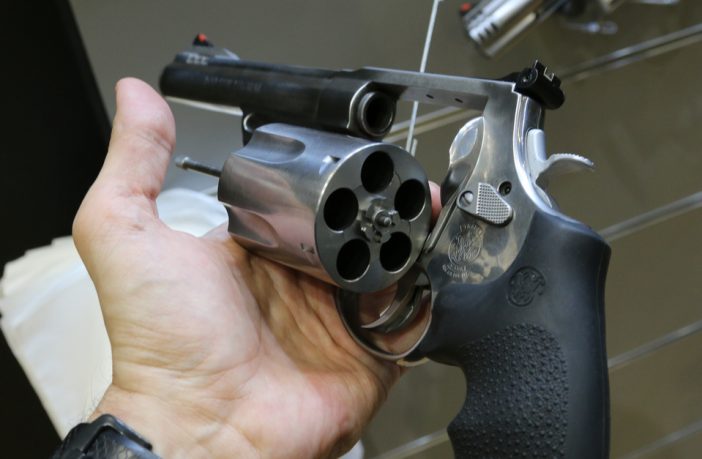 Hand holding a revolver with the cylinder open