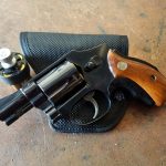 Smith and Wesson Model 40 revolver atop a black leather pocket holster