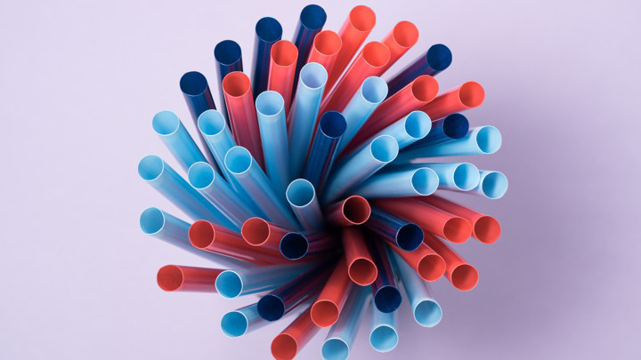Multi color drink pipette on violet purple background.